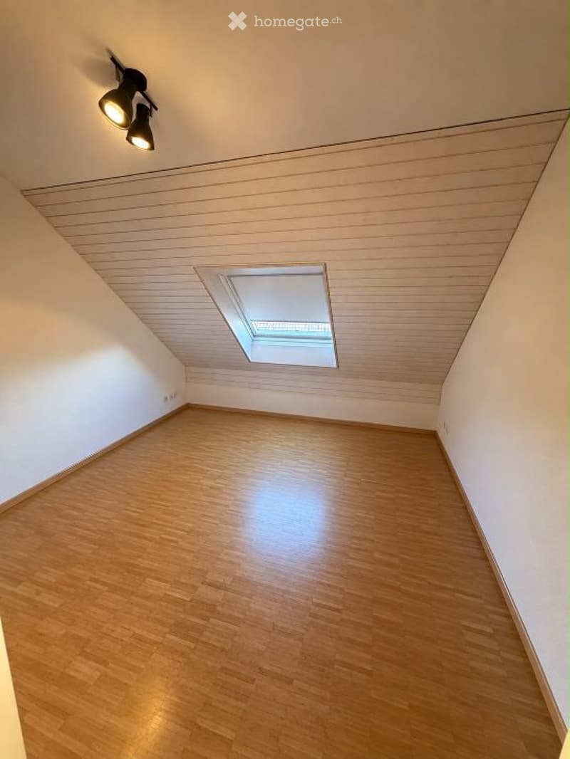 Empty room with wooden flooring, white walls, and a skylight window. No furniture or equipment present.