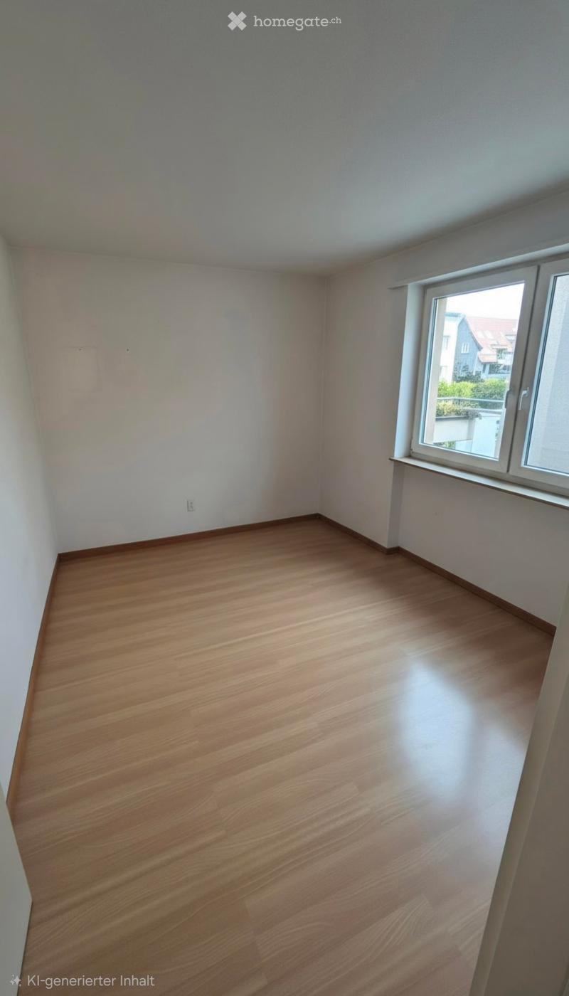 Empty room with wooden flooring and white walls, featuring a single window with white frame and a visible electrical outlet on the wall.