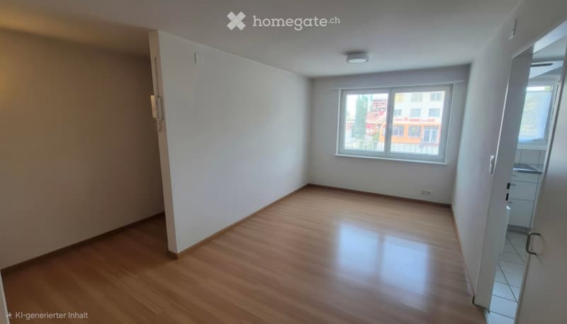 Empty room with wooden flooring, white walls, and large windows offering a view of the outside. No furniture or equipment is present.
