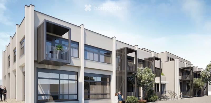 Modern multi-story residential building with large windows and balconies, featuring contemporary design and clean lines.