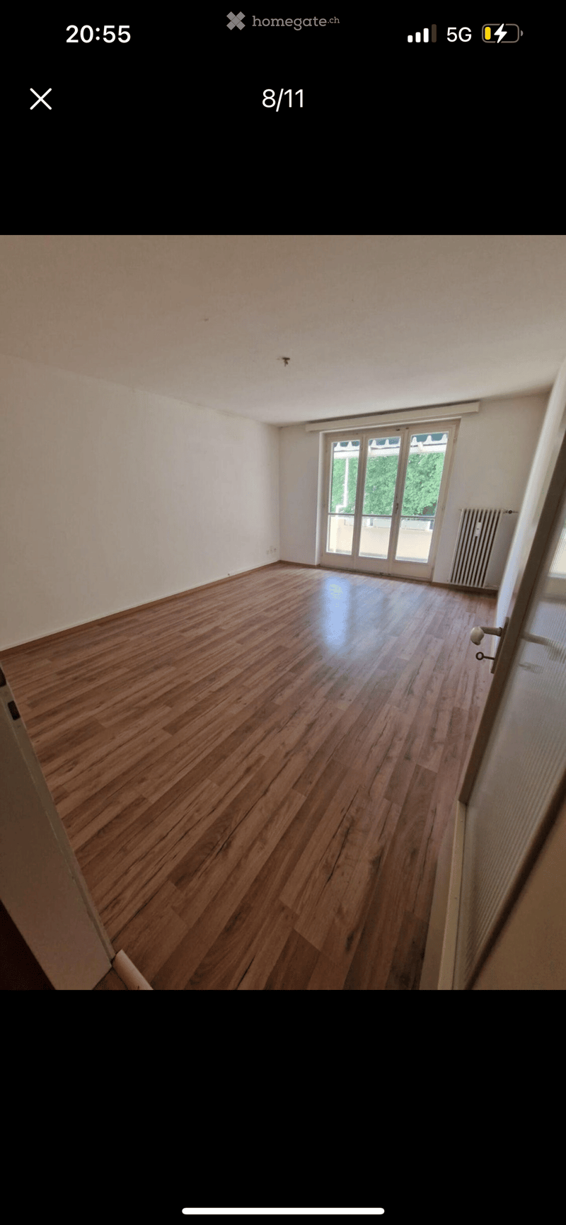 room with large balcony, hardwood floors, sliding glass door leading to balcony