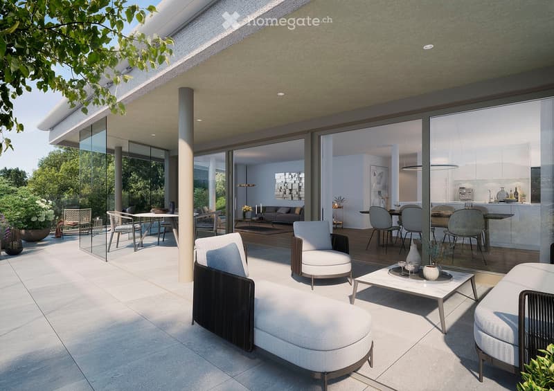 Modern outdoor patio with white and grey furniture, including a sofa, chairs, ottoman, and coffee table, surrounded by lush greenery and a view of the garden.