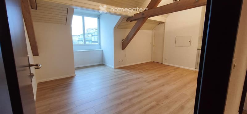 Empty room with wooden flooring, white walls, and a window with blinds. No furniture or equipment present.