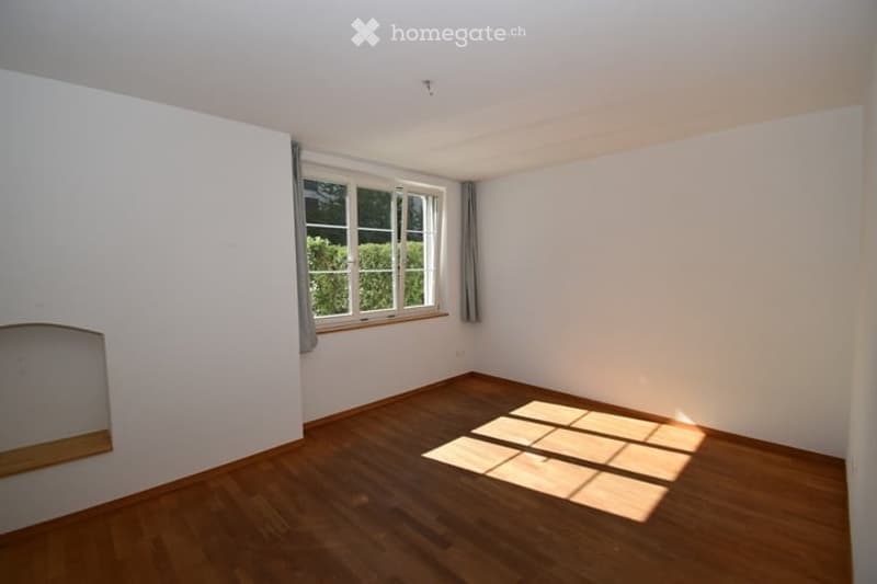 Completely empty room with bare white walls and wooden floor. No furniture or equipment.