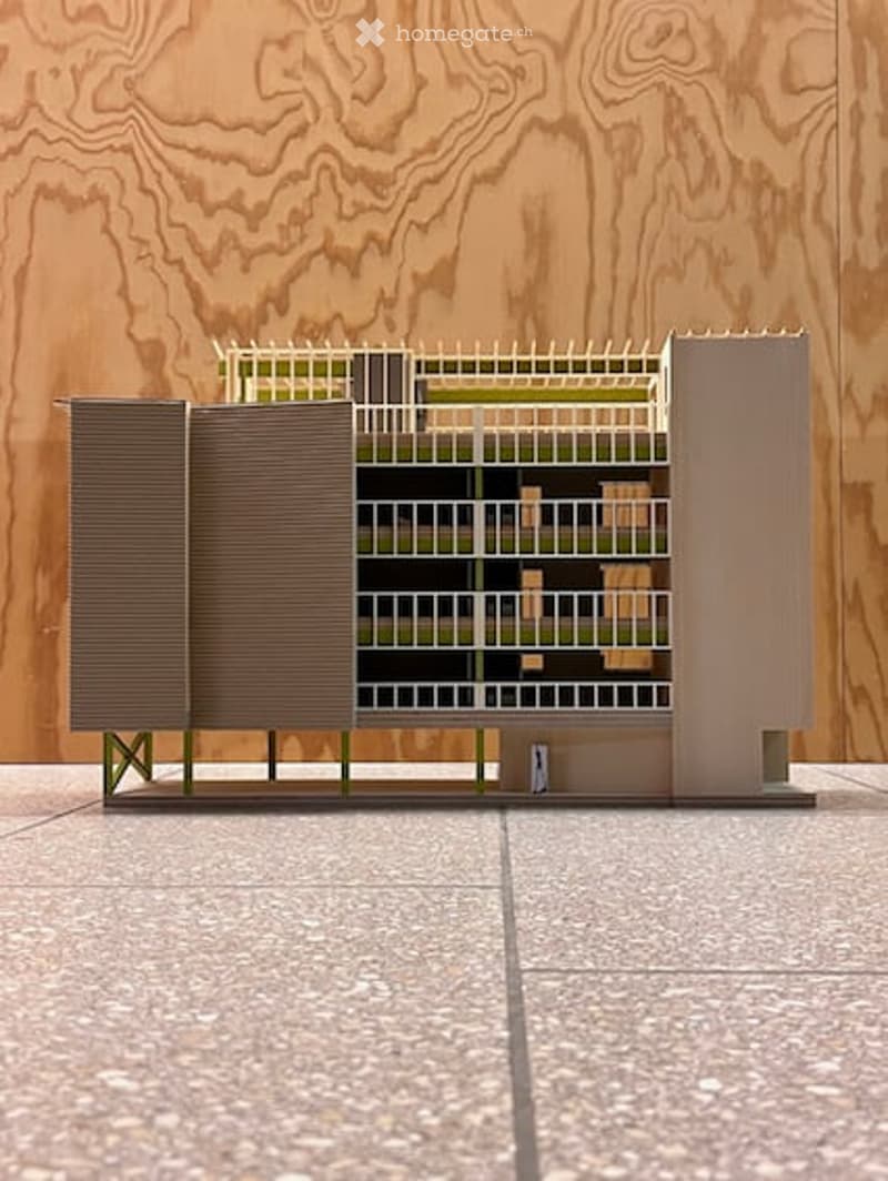 A 3D model of a modern building with multiple levels, featuring a grid-like structure and open spaces.