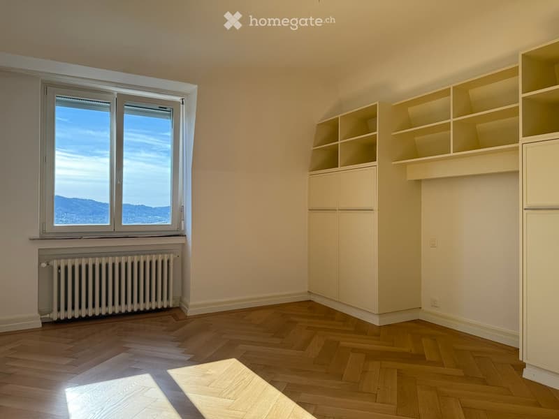 large windows, parquet flooring, white radiator, open shelving
