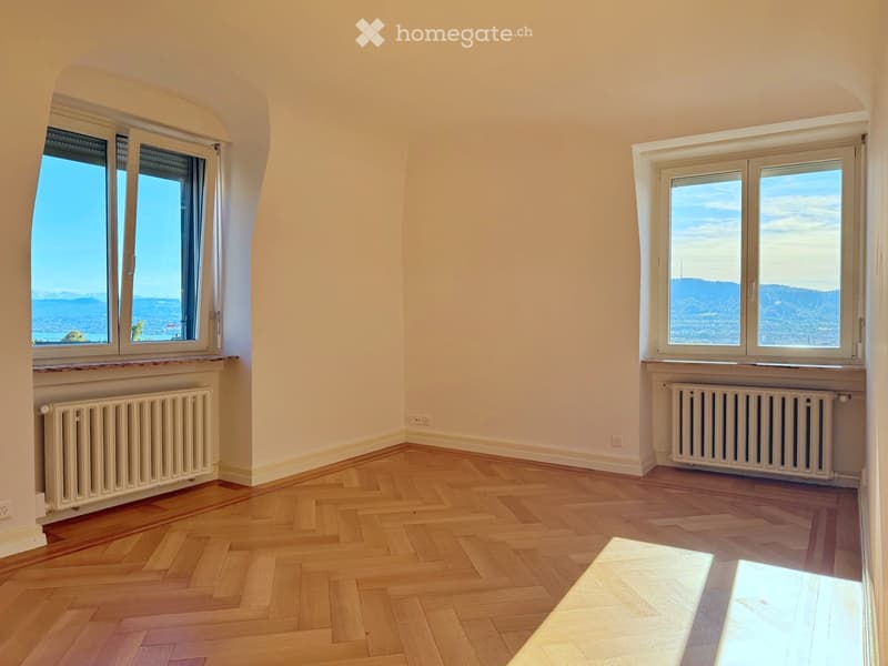 hardwood parquet flooring, two arched windows, white walls, two radiators