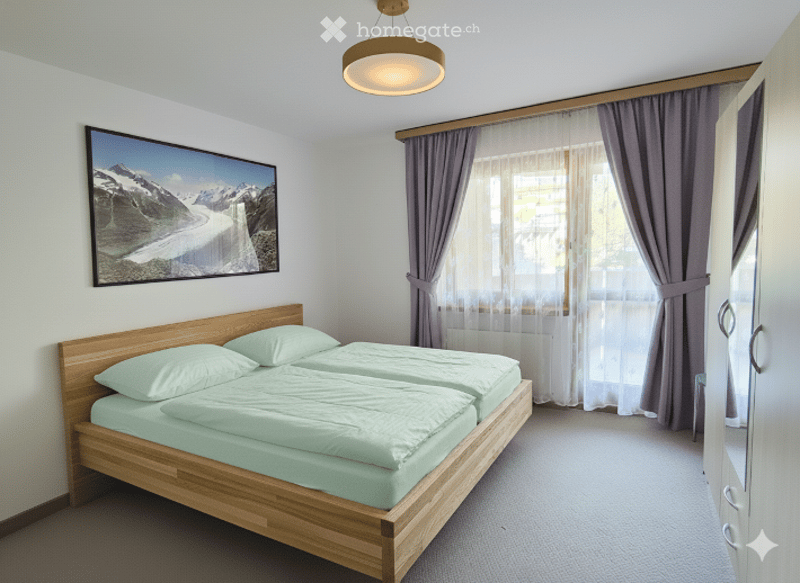 Cozy bedroom with a double bed, light green bedding, pillows, a large window with curtains, a picture frame on the wall, and a wardrobe.