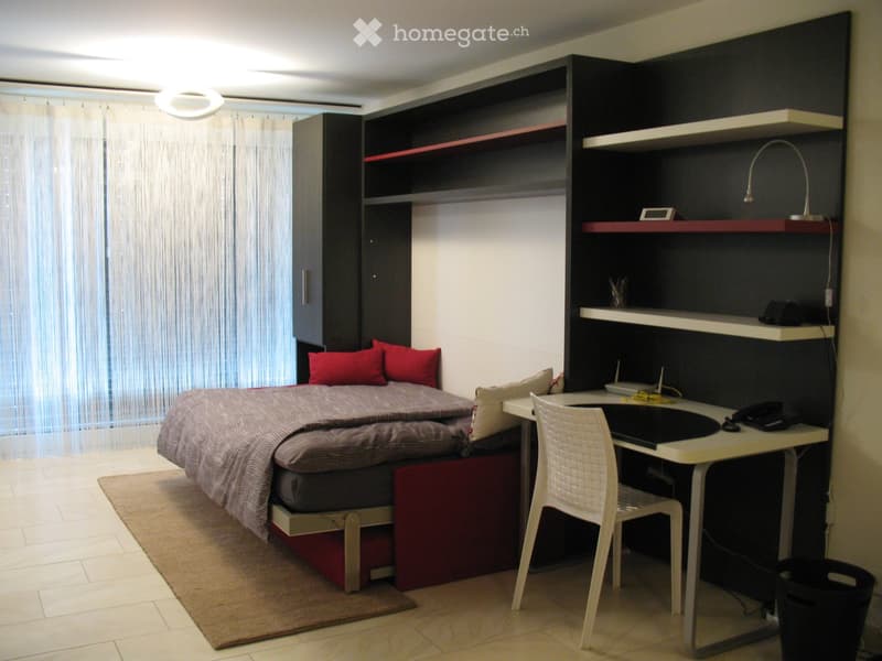bedroom with a desk, a bed, and a cabinet with shelves