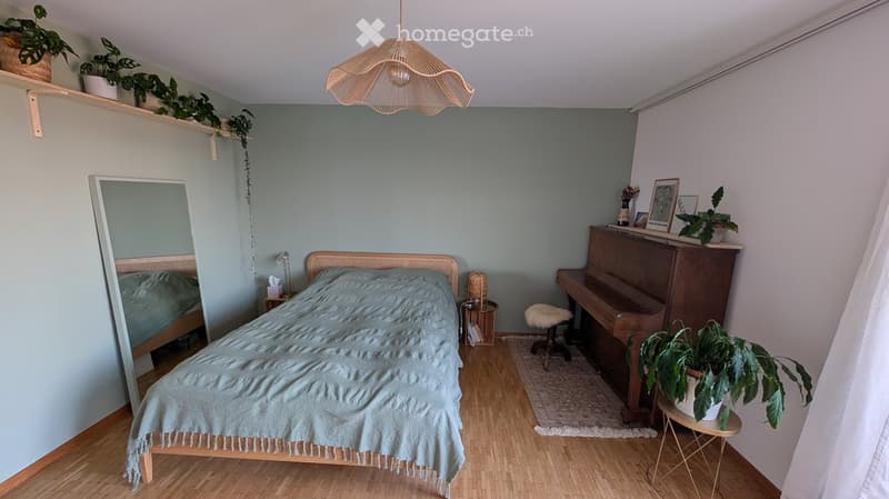 Cozy bedroom with a wooden bed, piano, small stool, mirror, nightstand, and potted plants on shelves and tables.