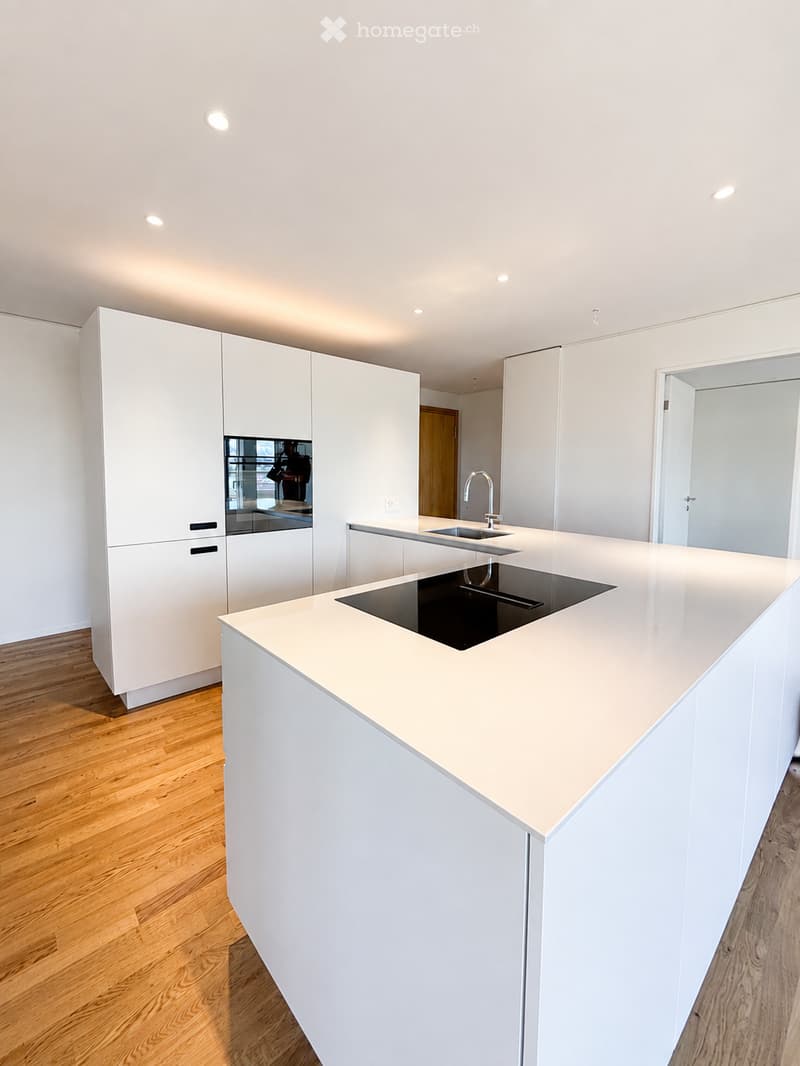 Modern kitchen with white cabinets, a central island, and a built-in sink.