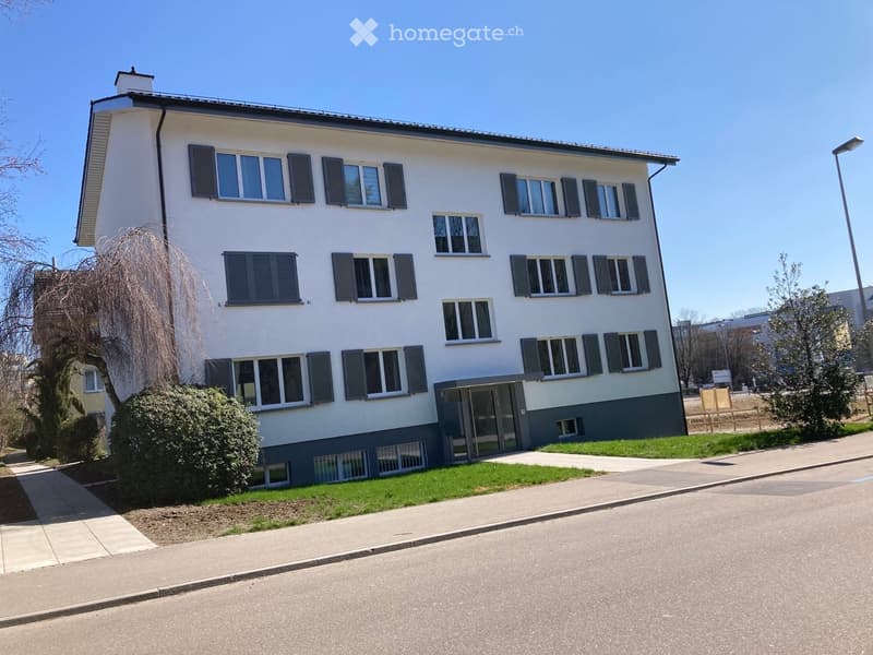 2 story apartment building, white facade, multiple windows, entrance with doors, pathway, street view, greenery around
