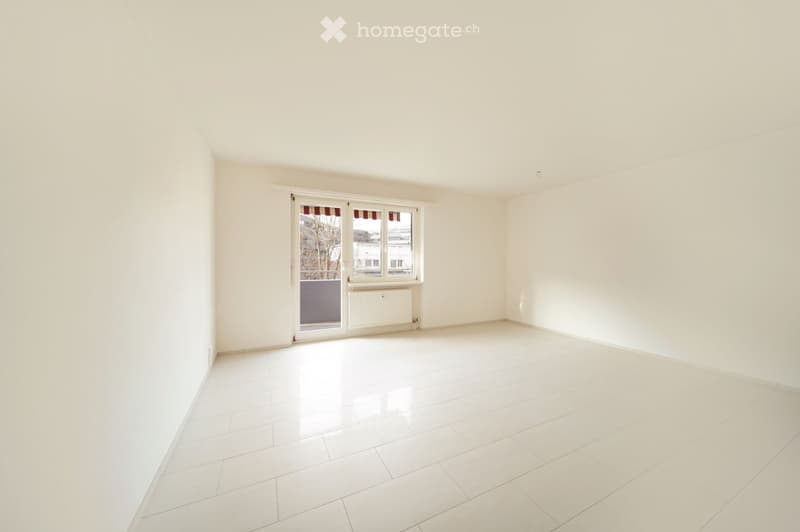Empty room with white walls, white tiled floor, and large window with blinds. No furniture or equipment present.