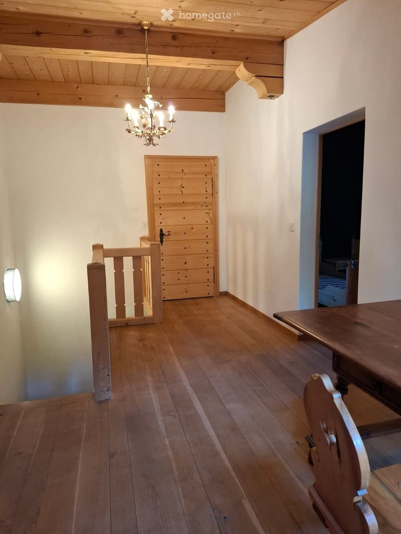 Wooden floor, wooden table, wooden chair, chandelier, wooden cabinet, wooden railing, wall-mounted light fixture.