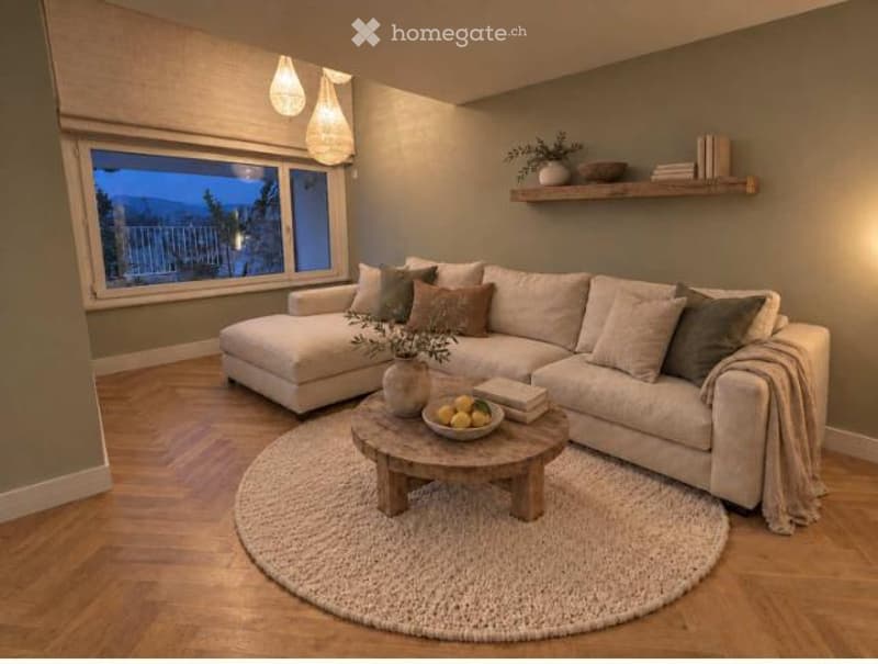 Modern living room with large window offering a view, light-colored sectional sofa, wooden coffee table, floor lamp, and decorative shelf with books and plants.