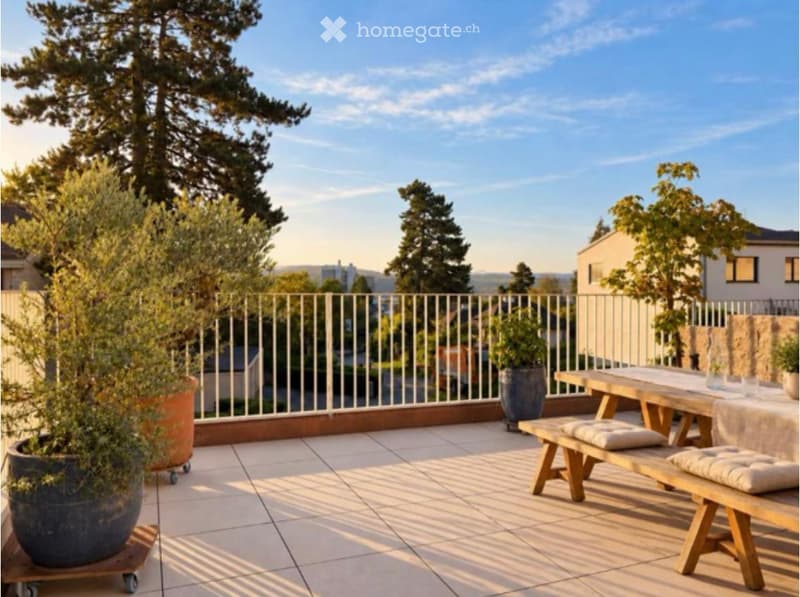 Balcony with wooden table, benches, potted plants, and a scenic view of trees and houses.