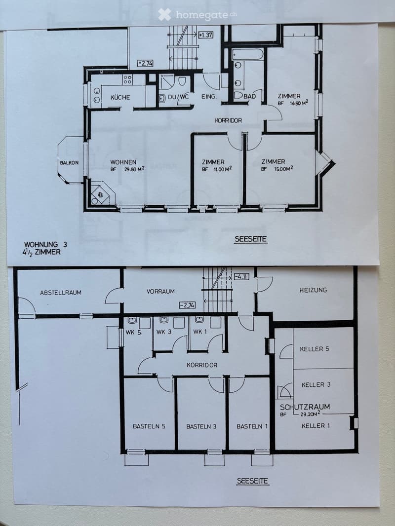 Floor plan showing a 4.5-room apartment on the upper level and a basement area with storage rooms and a heating room on the lower level. The upper level includes a kitchen, living room, three bedrooms, a bathroom, and a balcony. The lower level includes a