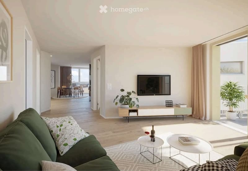 Modern living room with a green sofa, white coffee tables, a TV mounted on the wall, and a dining area visible in the background.