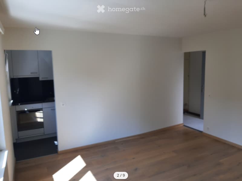 empty room, wooden floors, two entrance doors, kitchen cabinet with oven