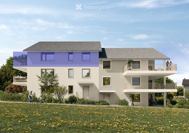 A modern two-story residential building with beige walls, grey roof, multiple windows, balconies, and a raised ground floor. The building is surrounded by a grassy area with yellow flowers and trees.