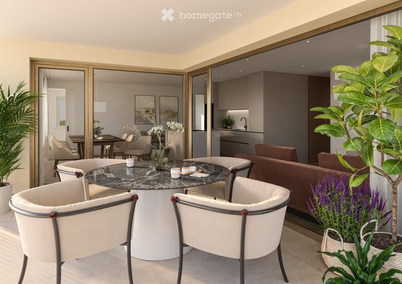 A modern, well-lit living space with a round marble table, white chairs, a sofa, and decorative plants.