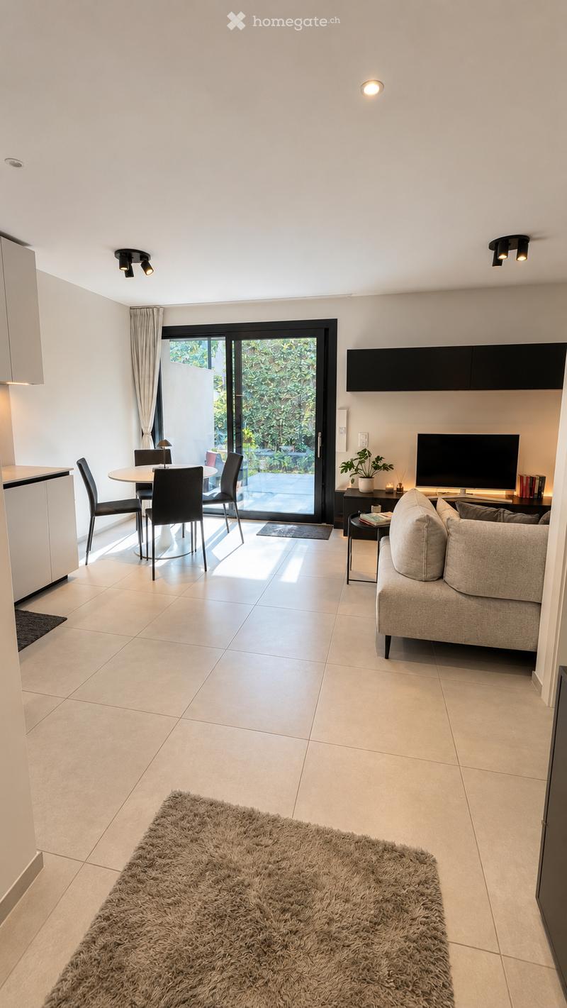 Modern living room with a grey sofa, coffee table, dining area with chairs and table, large sliding glass door leading to outdoor space, and a fluffy rug on the floor.