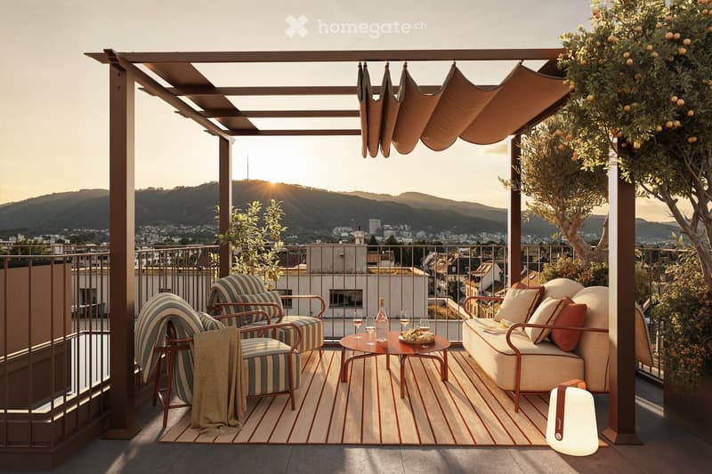 A stylish rooftop terrace with a view of the city and mountains, featuring a sofa, chairs, a coffee table, wine glasses, and a lamp.