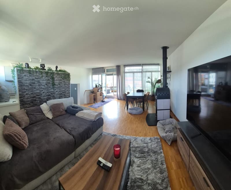 Living room with a sectional sofa, coffee table, fireplace, dining area, and TV stand.