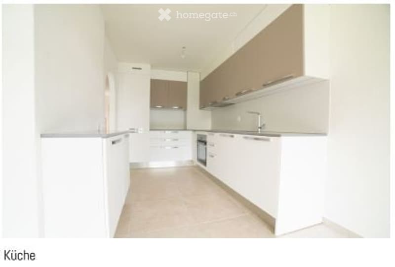Modern, minimalist kitchen with white cabinets, stainless steel appliances, and a clean, open layout.