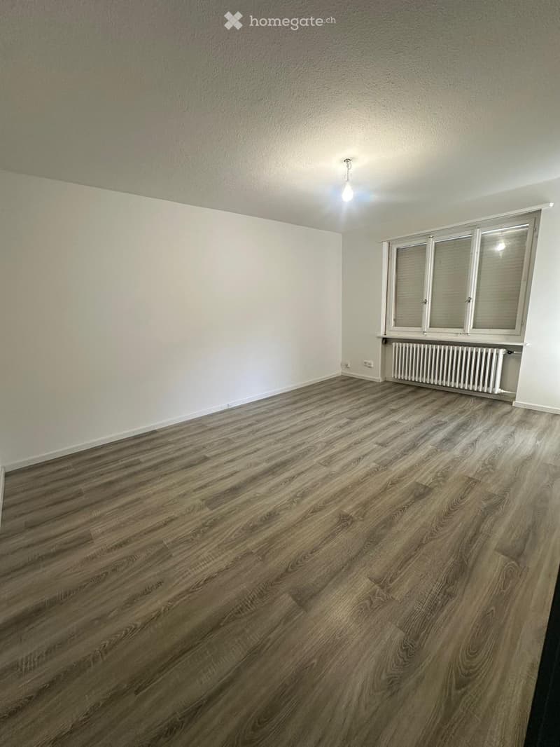 Empty room with wooden flooring, white walls, and a window with blinds. No furniture or equipment is present.
