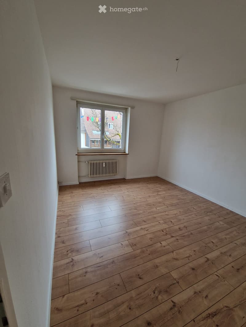empty room, hardwood floors, white walls, large window with white frames, white radiator