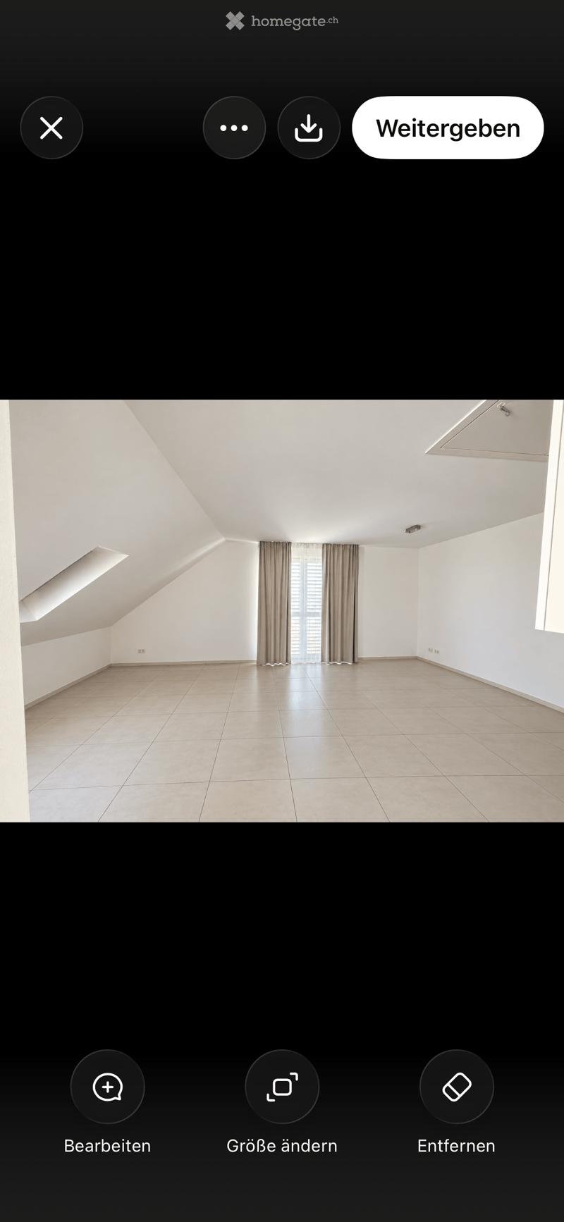 Empty room with white walls, tiled floor, and large windows with curtains. No furniture or equipment present.