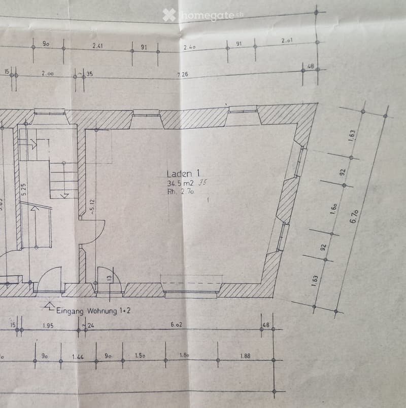 Floor plan showing a commercial space labeled 'Laden 1' (Shop 1) with dimensions and an entrance to 'Wohnung 1+2' (Apartment 1+2).