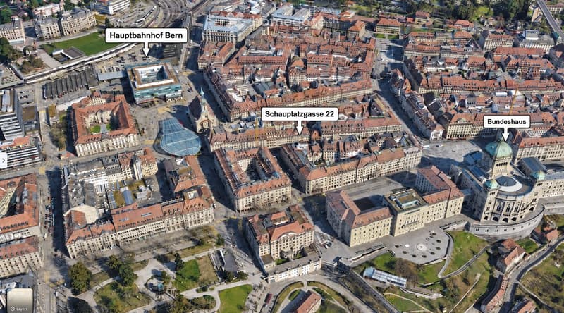 Aerial view of a dense urban area with numerous buildings, labeled landmarks including Hauptbahnhof Bern, Schauplatzgasse 22, and Bundeshaus, surrounded by streets and green spaces.