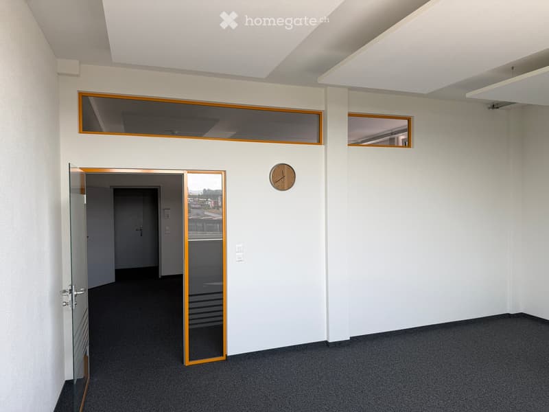 Empty room with white walls, carpeted floor, glass door, and a clock on the wall.