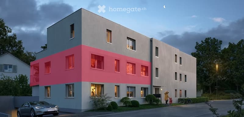 Modern multi-story building with a combination of grey and pink facades, large windows, and a contemporary design. The building is surrounded by small shrubs and trees, with a parked car visible in the foreground.