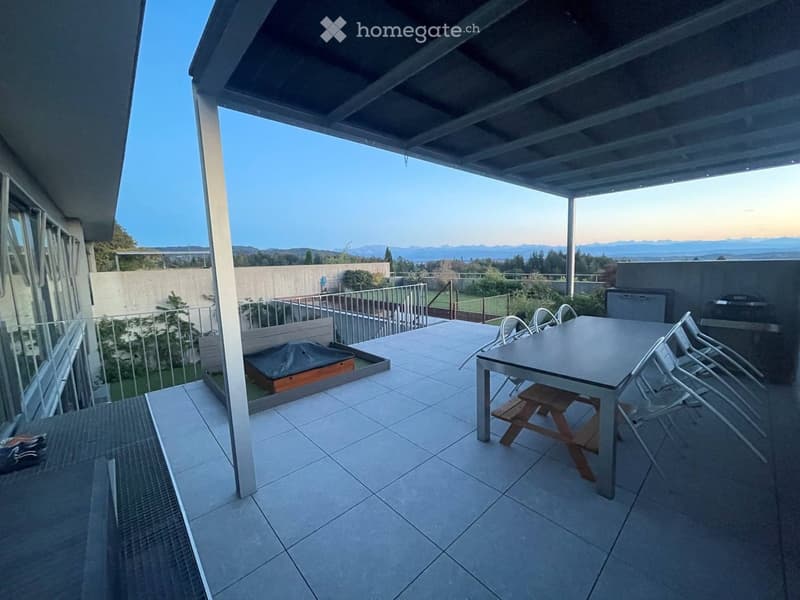 Balcony with tiled floor, covered roof, table and chairs, picnic table, scenic mountain view.