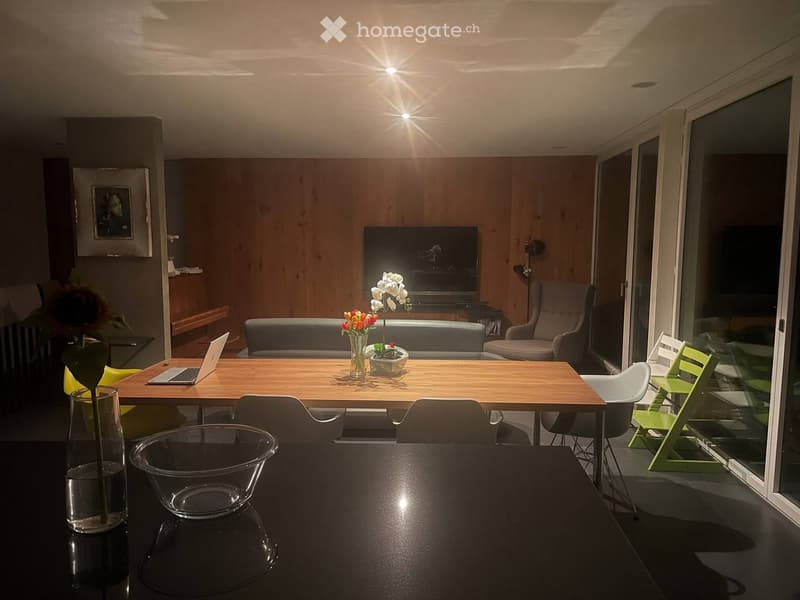 Modern living room with wooden table, laptop, sofa, television, and decorative vases.