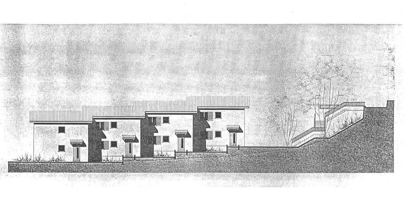 A multi-level modern house with a flat roof, multiple windows, and a raised ground floor connected by an outdoor staircase.