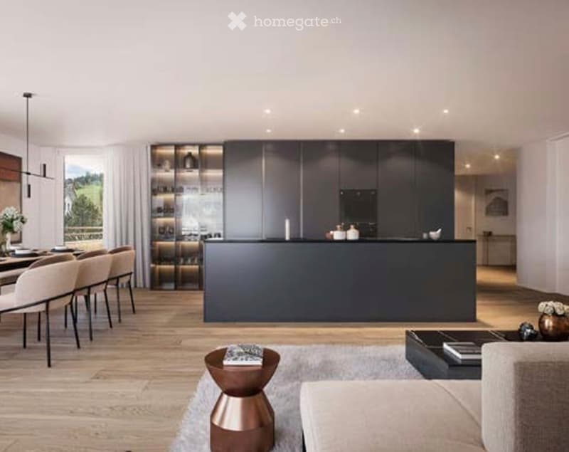 Modern open-plan living and dining area with a sleek kitchen island, pendant lights, a sofa, coffee table, dining table with chairs, and a view of a green landscape through large windows.