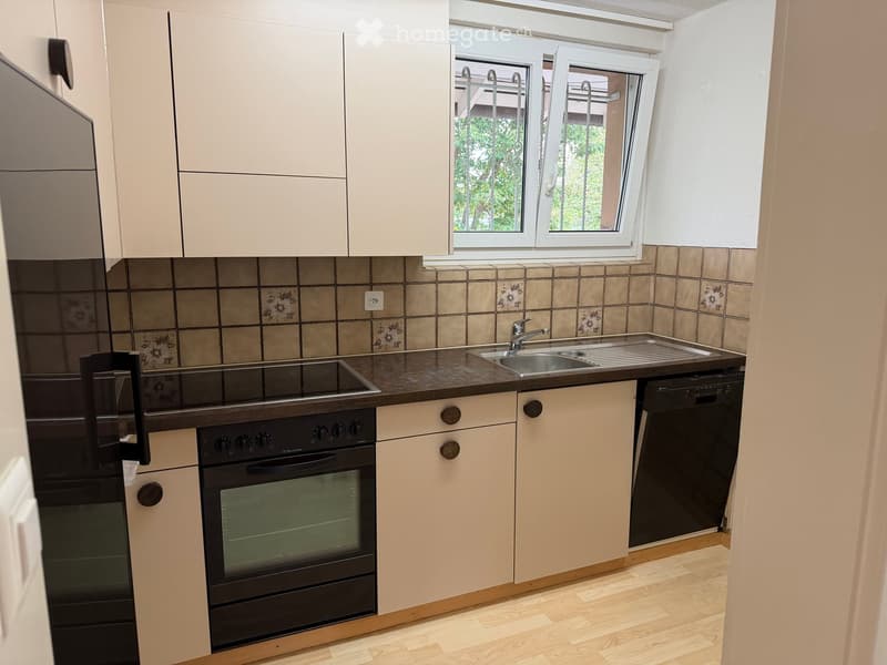 Modern kitchen with white cabinets, stainless steel appliances, and a tiled backsplash. Features include a refrigerator, oven, dishwasher, sink, and faucet.