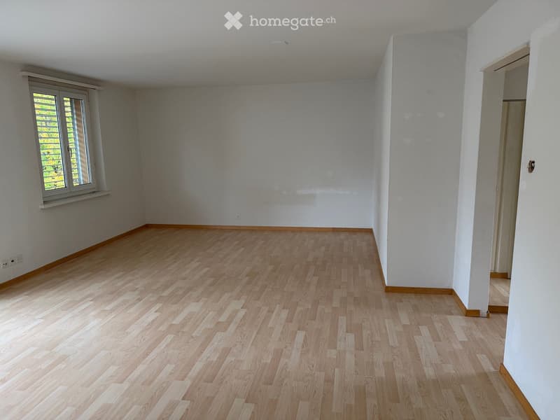 Empty room with light wooden flooring, white walls, and a window with blinds. No furniture or equipment present.