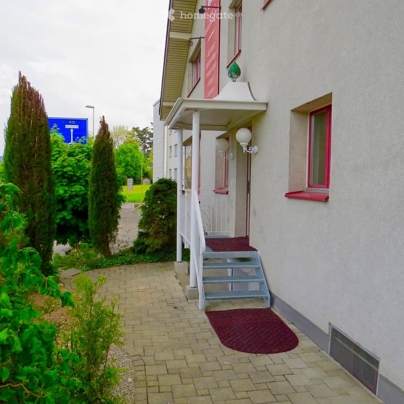white building, red trim, red carpet, white railing, lamp