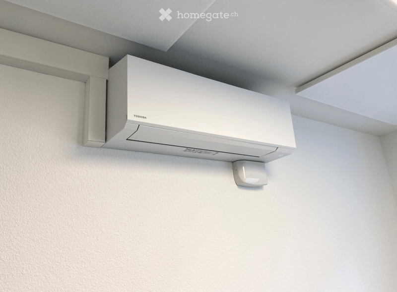 A white Toshiba air conditioner unit mounted on a white wall with a sleek, modern design.