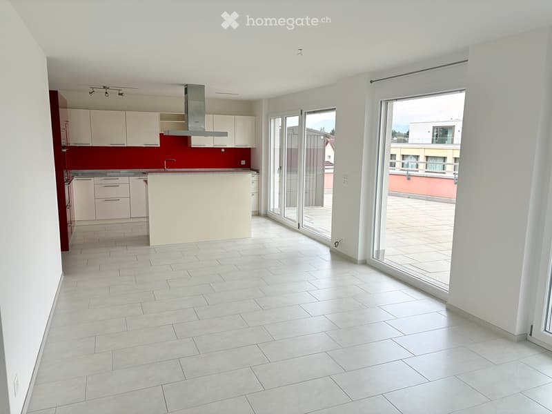 Empty kitchen with white cabinets, a red backsplash, and a large sliding glass door leading to a balcony.