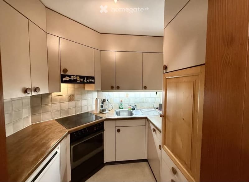 Modern kitchen with light-colored cabinets, wooden countertops, and stainless steel appliances including a sink, faucet, and oven. A coffee maker is placed on the counter.