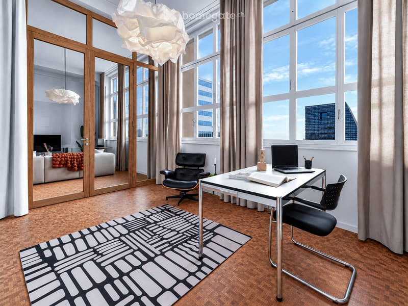 Modern, well-lit room with large windows, wooden flooring, a sofa, a desk with a laptop, and a chair.