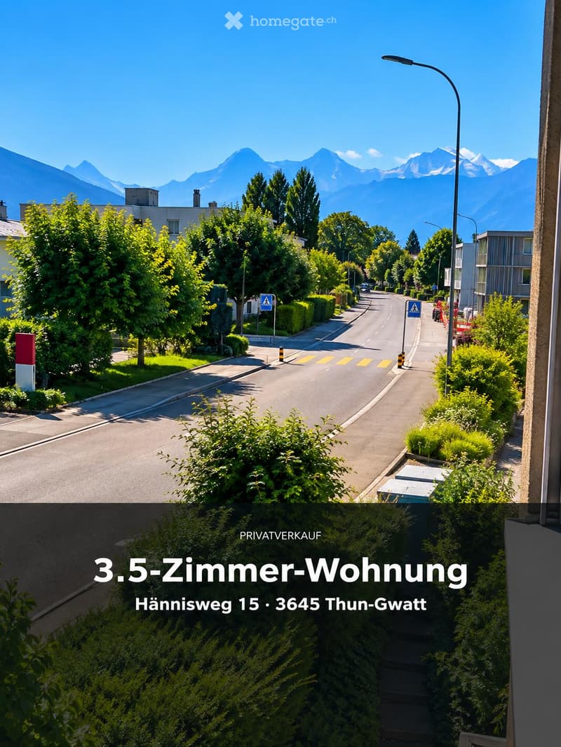 Residential street lined with trees and houses, with a clear view of mountains in the background.