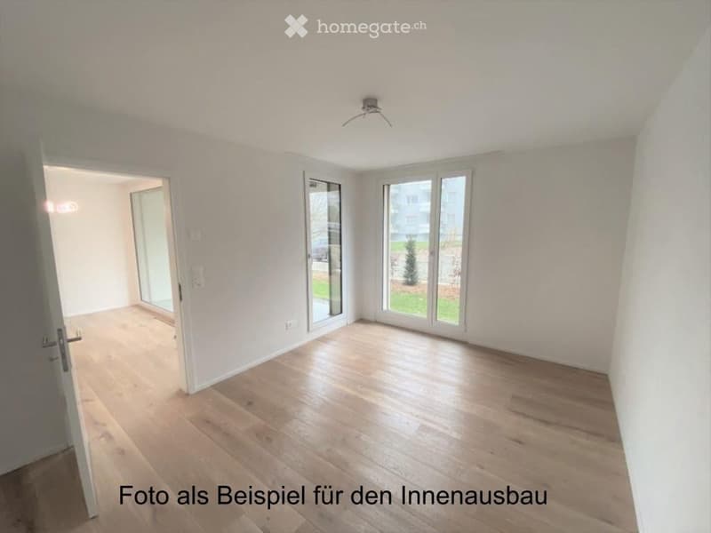Empty room with light wooden flooring, white walls, large windows, and a sliding glass door leading to another space.