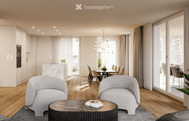 Modern living and dining area with light wood flooring, grey sofas, a round coffee table, a dining table with chairs, and a sleek kitchen area with cabinets and an oven. Large windows with curtains allow natural light to fill the space.